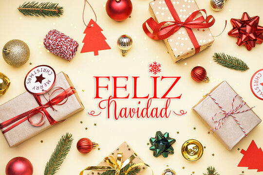 Gift boxes, decorations and text FELIZ NAVIDAD (Spanish for Merry Christmas) on beige background