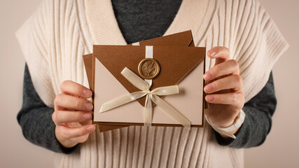 two Gift Certificate, handmade invitation envelope with wax seal on woman hands. close up view