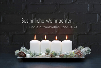 Weihnachtsgrußkarte:  Vier weiße brennende Kerzen mit Weihnahtsschmuck und Zweigen vor einer...