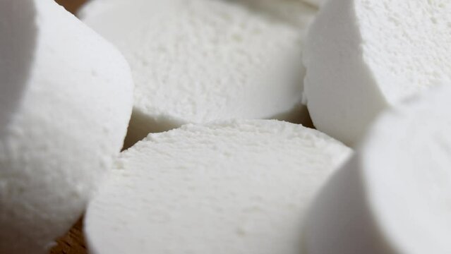 Sliced Chevre goat soft cheese. Traditional dairy product. Rotation. Macro shot