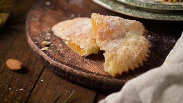 A crescent-shaped pastry whose filling is made of eggs and almonds wrapped in crispy dough, cut in an artisanal way and sprinkled with sugar.