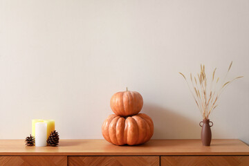Wooden cabinet with pumpkins, pampas grass and candles in living room