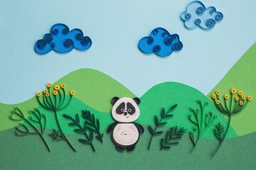 Funny panda quilling character in field, near trees in summer day with clouds. Happy cute panda in garden. Save The Earth Pandas live here. Ecology concept. Hand made of paper quilling technique.