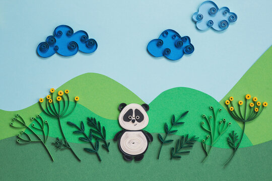 Funny panda quilling character in field, near trees in summer day with clouds. Happy cute panda in garden. Save The Earth Pandas live here. Ecology concept. Hand made of paper quilling technique.