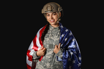 Young female soldier in uniform with flag of USA on black background