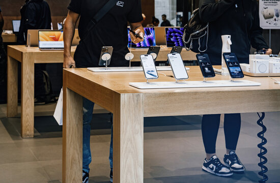 Paris, France - Sep 22, 2023: The interior of a bustling Apple store with people testing and admiring the latest Apple computers and iPhone 15 Pro Max on launch day