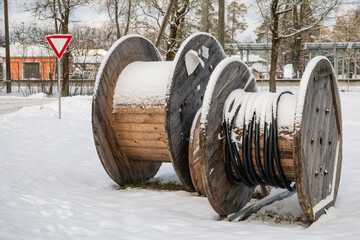 Wooden coil for wires. Empty cable reel. Winter landscape