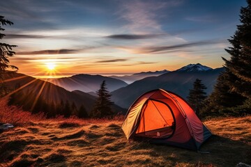 A camping tent pitched high in the mountains during sunset.