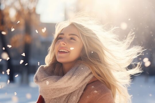 Beauty Winter Girl Blowing Snow. Cheerful beautiful young women having fun in Winter Park. A beauty girl on the winter background