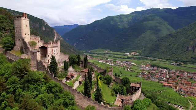 Medieval castles of northern Italy, Trentino Alto Adige region. Aerial drone overflight 4k of Castello di Avio and village surrounded by Alps mountains
