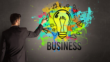 businessman drawing colorful light bulb