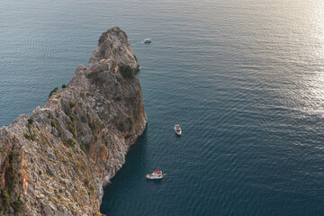 Two motor boats in the sea near the cliff in Turkey. View from above.