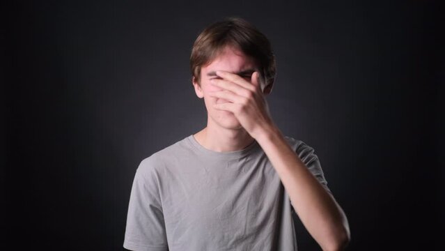 Young Caucasian Man Facepalming on black Background