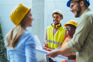 Team of construction workers discussing project details with executive supervisor. Group of architects and civil engineers inspecting construction site. Structural engineer and architect discussing.