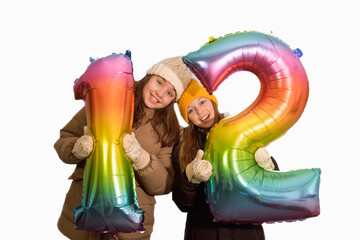 Girlfriends are holding large inflatable numbers 12 twelve. Girls 10-12 years old. card. white...