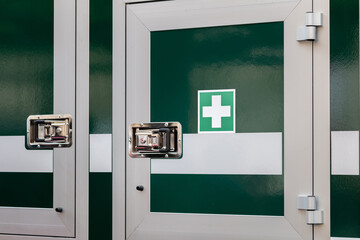 Mobile medkit compartment locked door on a vehicle with a green white cross symbol, professional...