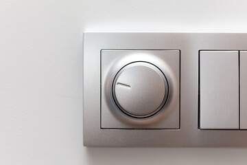 Modern smart rotary knob light dimmer light switch mounted on a wall, front view, frontal shot,...