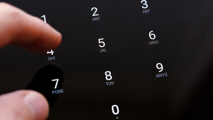 Man's hand finger entering the 4 digit PIN number on a touch screen display unlocking a generic...