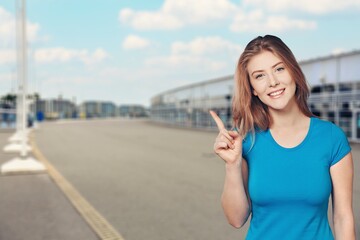 Happy pretty student girl pointing finger