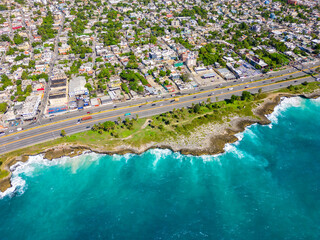 Aerial top view of The Autopista Las Americas along the rocky shore of turquoise caribbean sea....