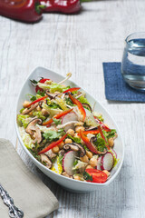 High angle view photo of a mixed green salad in a white modern bowl