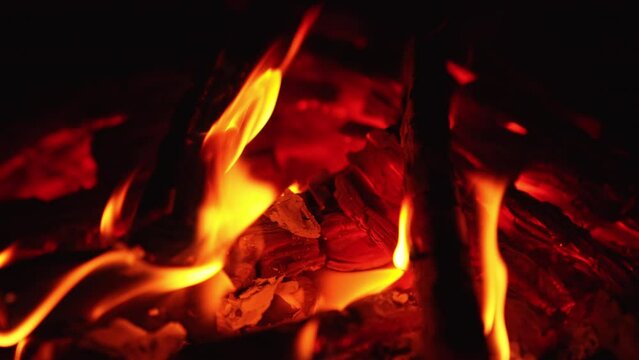 Red smoldering pieces of wood with some little flames on. Beautiful bonfire close up.