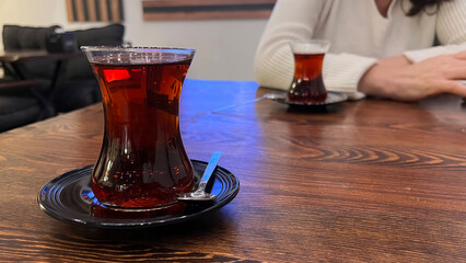 A glass of Turkish tea on a wooden table.