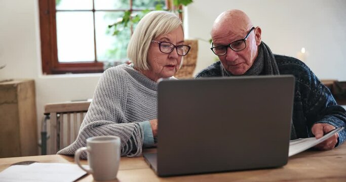 Senior, couple or documents with laptop for discussion, planning or investment for retirement in living room. Elderly, man or woman or technology, communication or finance at table in lounge of home