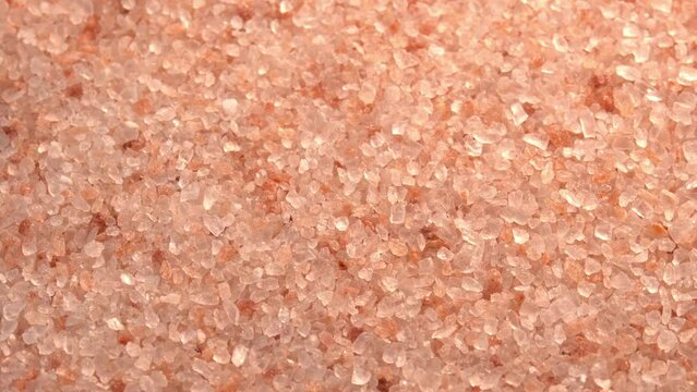 Pink himalayan salt or rock salt rotating close up background top view sun light. Trace minerals salt used for cooking and food presentation, decorative lamps, and spa treatments