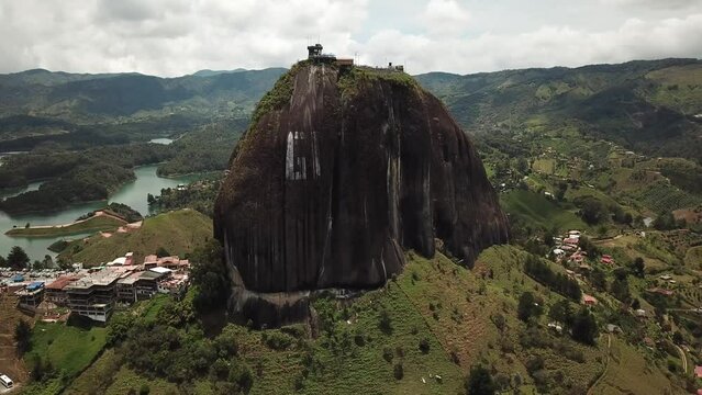 Aerial drone footage of El Penon de Guatape near Medellin in Antioquia, Colombia. Large and unique alone rock with stairs to the top, touristic place. Big stone in Colombia. High quality 4k footage.