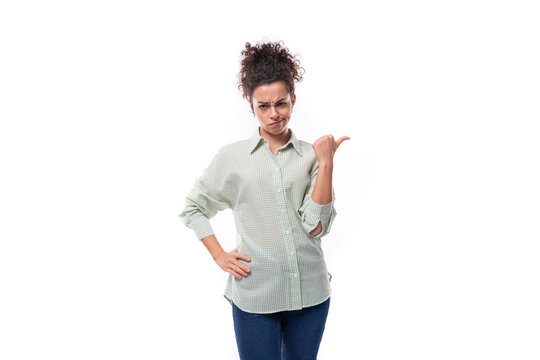 a pretty young black-haired curly woman with a careless styling bun in a shirt contemptuously points her hand to the side