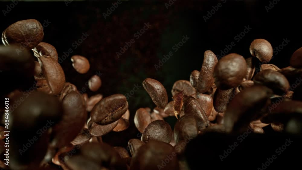 Poster super slow motion of falling coffee beans isolated on black background. macro shot. filmed on high s