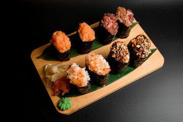 Assorted sushi set wrapped in nori with tuna, salmon, rice, wasabi, ginger and caviar