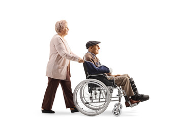Elderly woman pushing an elderly injured man in a wheelchair