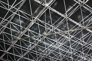 Hall roof construction background. Metal pipes grid texture. Iron beams building interior. Ceiling of industrial hall. Warehouse industrial building. Factory architecture.