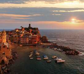 Beautiful sunset in summer Vernazza - one of five famous villages of Cinque Terre National Park in Liguria, Italy, suspended between Ligurian sea and land on sheer cliffs. People unrecognizable.