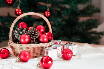 Basket brimming with rustic pine cones with vibrant red ornaments. Beside the basket, silver-wrapped presents embodies the spirit of holiday charm and gift-giving, in Christmas red and green colors