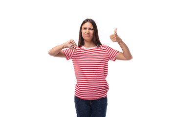 young upset sad european brunette woman dressed in a striped t-shirt on a white background
