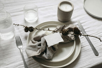 New Year, Christmas styled neutral table setting. White plate, silver cutlery and linen napkin....