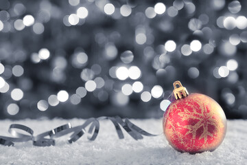 Christmas ball on white snow isolated on gray background.