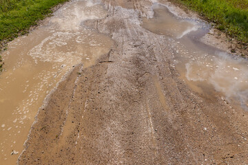 a country road covered with puddles of dirty water