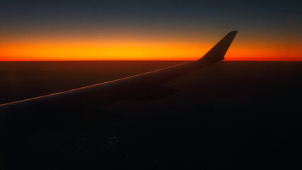 Red sky as seen through window of an airplane