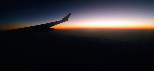 Naklejka na ściany i meble Red sky as seen through window of an airplane