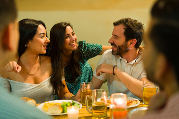 Beautiful smiling woman hugging her friends having fun at dinner