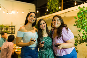 Attractive hispanic women friends enjoying drinking wine - obrazy, fototapety, plakaty