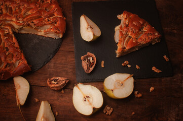 pear pie on a black serving board on a wooden table,