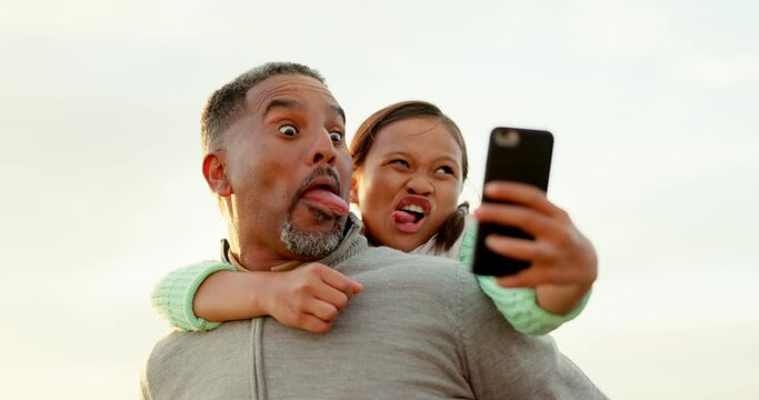 Father, girl and funny face for selfie outdoor, smile or bonding with love in nature for social network. Dad, piggyback and child with photography for memory, profile picture or comic post for blog