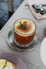 Spiced apple coffee with fresh apple slices mocktail drink in cafe or restaurant. Refreshing Summer cold cocktail