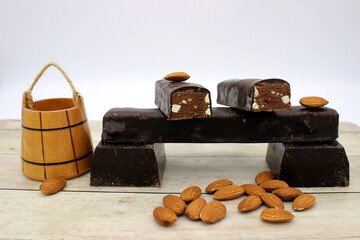chocolate bar with almonds on a white wooden