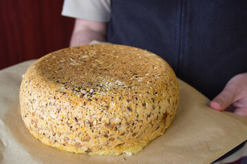 A man in a black apron holds